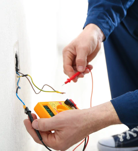 electrician measuring the resistance prior to installation of wiring connection for new socket